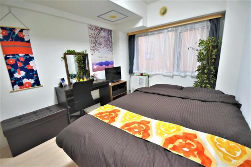 a bedroom with a bed and a desk with a computer at Carid Shiraishi In front of the station - Vacation STAY 15516 in Sapporo
