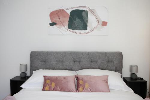 a bed with a headboard and two pillows on it at Apartman Grey in Jastrebarsko