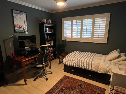 1 dormitorio con cama, escritorio y ordenador en Chic Venice Beach Bungalow Steps from the Canals & Beach en Los Ángeles