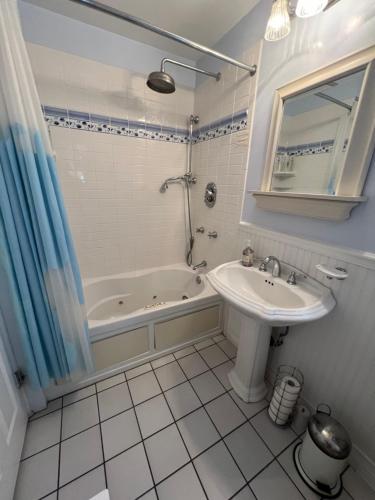 a bathroom with a tub and a sink and a bath tub at Chic Venice Beach Bungalow Steps from the Canals & Beach in Los Angeles