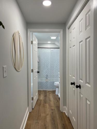 a white bathroom with a toilet and a mirror at 5BR 4B Huge Space with 2 Level Game Barn in Greenville
