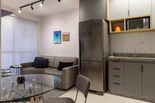 a kitchen with a glass table and a refrigerator at Apartamento moderno, com home office e garagem. in Goiânia