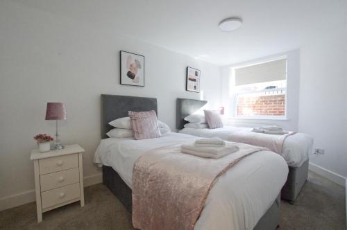 a bedroom with two beds and a window at 2 Bedroom Flat - Free Parking - Close to Beach in Portsmouth