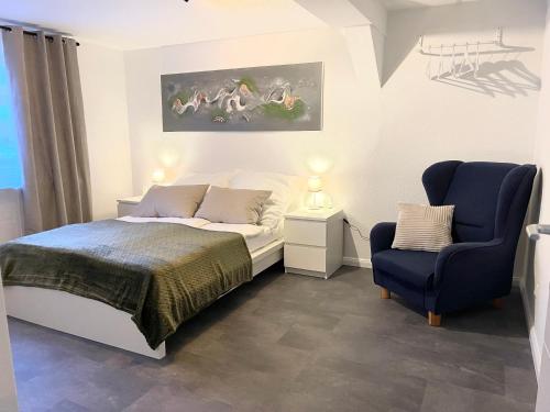 1 dormitorio con 1 cama y 1 silla azul en Casa Bella en Guxhagen