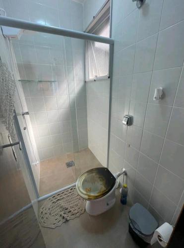 a bathroom with a toilet and a shower with a window at Praia Martin de Sá SP. in Caraguatatuba