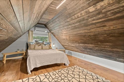 a room with a bed and a wooden wall at Tiny Victorian built on TV show 2br 1 ba in Gainesville