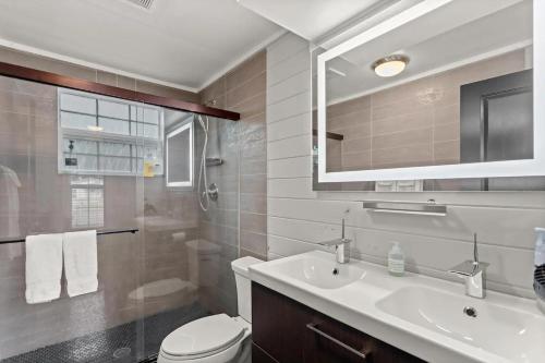 y baño con lavabo, aseo y espejo. en Tiny Victorian built on TV show 2br 1 ba en Gainesville