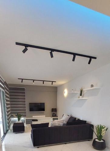 a living room with a black couch and a tv at Smart Living-2Bed Pallouriotissa, Nicosia in Nicosia