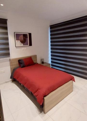 a bedroom with a bed with a red blanket at Smart Living-2Bed Pallouriotissa, Nicosia in Nicosia