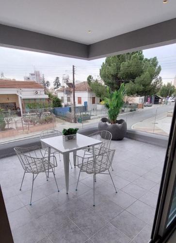a white table and chairs on a patio at Smart Living-2Bed Pallouriotissa, Nicosia in Nicosia