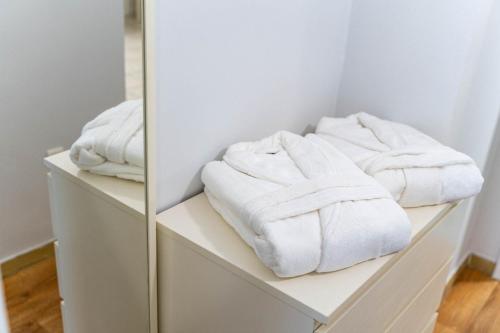 une rangée de serviettes assises sur des étagères dans une salle de bains dans l'établissement Angelica apartment, à Aigio