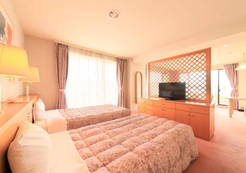 a hotel room with two beds and a television at Kamogawa Grand Tower - Vacation STAY 53387v in Kamogawa