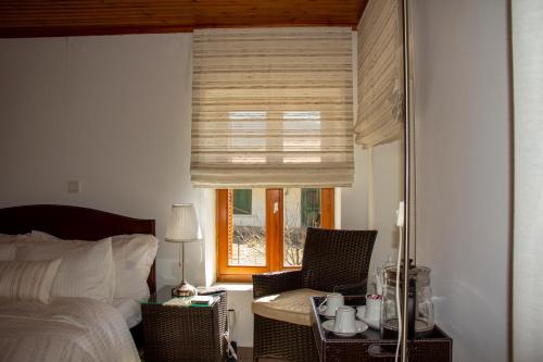 a bedroom with a bed and a window with a table and chairs at Private House, Miriki Village in Miríki