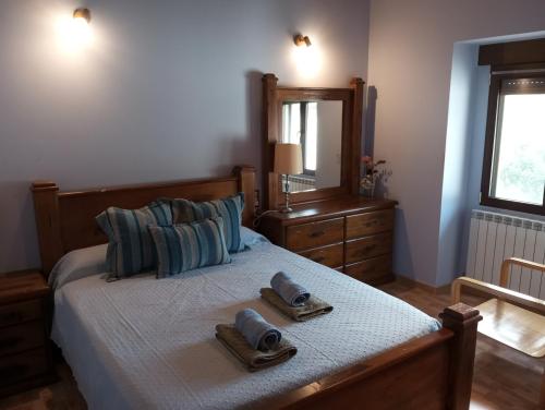 Maittia-Larraona في Larraona: غرفة نوم بسرير مع مناشف ومرآة