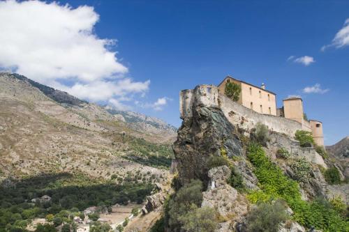 a castle on the side of a mountain at Authentique maison de village de Gavignano 