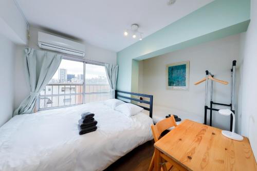 een slaapkamer met een bed, een bureau en een raam bij Grace Heiwajima - Vacation STAY 15464 in Tokyo