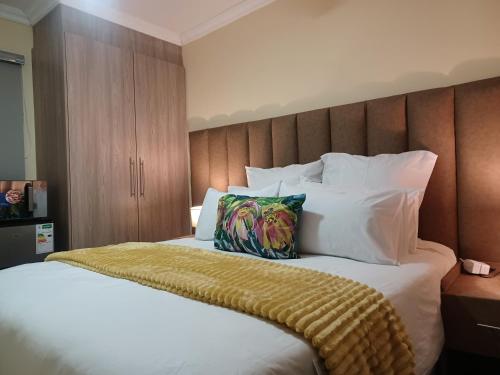 1 dormitorio con 1 cama grande con sábanas y almohadas blancas en Sindy's Chalets, en Margate