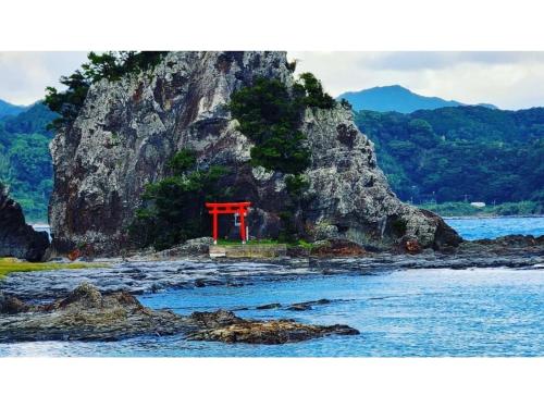 a red toriiption on a rocky island in the water at Pulse Inn Katsuura - Vacation STAY 44377v in Temma