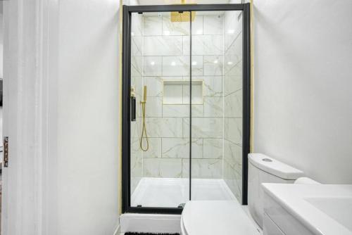 y baño blanco con ducha y aseo. en Entire rental unit hosted by Lux Living en Oxford