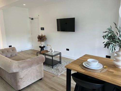 een woonkamer met een tafel en een stoel bij Entire rental unit hosted by Lux Living in Oxford