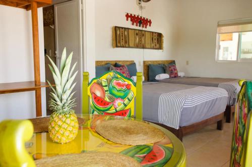 Un dormitorio con una cama y una mesa con una piña. en LALORA Hotel & Villas, en San Patricio Melaque