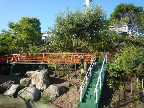 a bridge over a river with rocks and trees at Seaside Hostel Light House - Vacation STAY 82325v in Onomichi