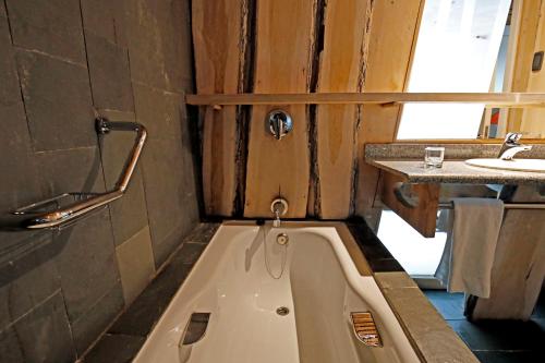 a bath tub in a bathroom with a sink at Remota Patagonia Lodge in Puerto Natales
