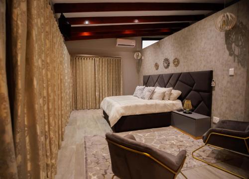 a bedroom with a king sized bed and a couch at Villa 698 tswinga in Thohoyandou