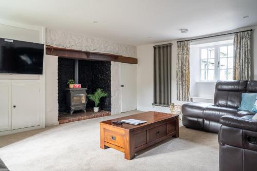 ein Wohnzimmer mit einem Sofa und einem Couchtisch in der Unterkunft Charming Family Farmhouse near Lyme Regis in Axminster