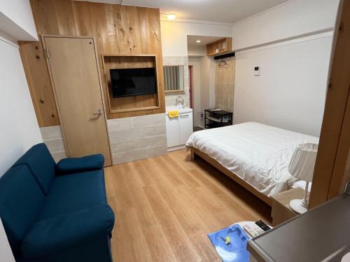 1 dormitorio pequeño con 1 cama y 1 silla azul en Rhodes Kagurazaka - Vacation STAY 77324v en Tokio