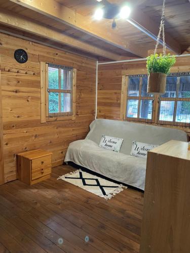 a bedroom with a bed in a wooden cabin at LES CHALETS DE VANESS' le Mahé in Digoin