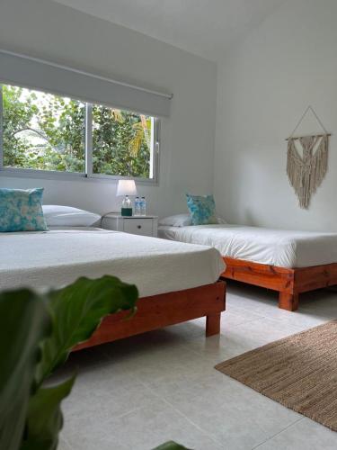 a bedroom with two beds and a window at Casa Grande Hotel Restaurant in Las Terrenas