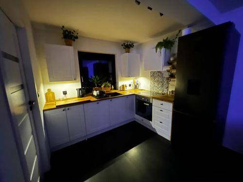 a kitchen with white cabinets and a sink and a window at PETE HOUSE in Ustrzyki Dolne
