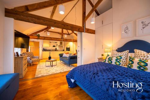 een slaapkamer met een blauw bed en een woonkamer bij The Penthouse, Henley-On-Thames in Henley on Thames
