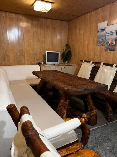 a room with a wooden table and chairs and a tv at Спортохота in Cherkasy