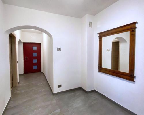 a hallway with a mirror and a red door at Casa vacanze Da Bianca in Castelfondo