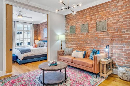 uma sala de estar com um sofá e uma parede de tijolos em The Jasmine Nola em Nova Orleans
