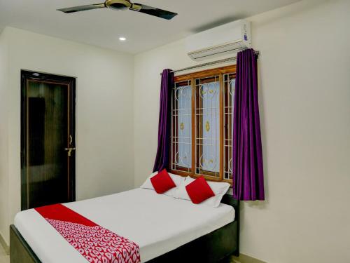 a bedroom with a bed with red and white pillows at Flagship Hotel The Guest Land in Visakhapatnam