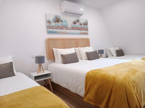 um quarto com 2 camas com lençóis amarelos em Aveiro Ria House E em Aveiro