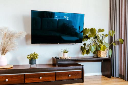 a living room with a flat screen tv on a wall at Rest In Sanok Apartment in Sanok