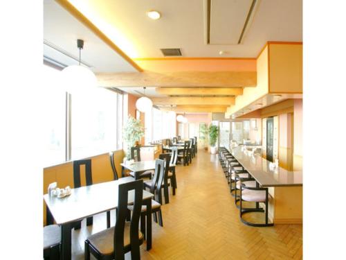 a restaurant with tables and chairs and windows at Hotel Montagne Matsumoto - Vacation STAY 73668v in Matsumoto