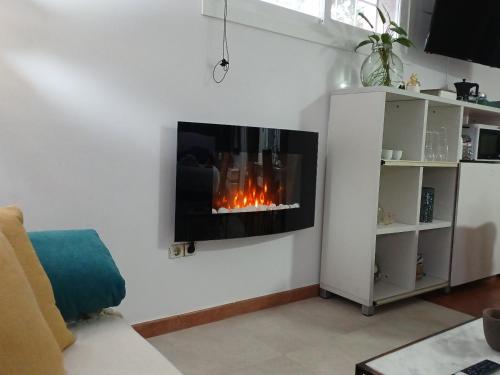 sala de estar con chimenea en la pared en Casa Raposeira, en Ourense