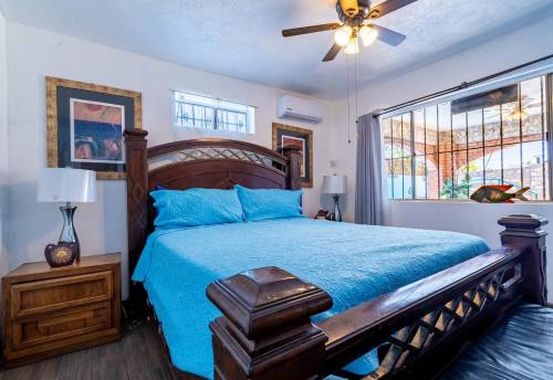 a bedroom with a bed with a blue comforter and a fan at Huge Family - 5 bedroom sleeps 16 with private pool home in San Felipe