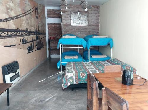 a room with two bunk beds and a table at Hostel el Tata in Potrero de los Funes