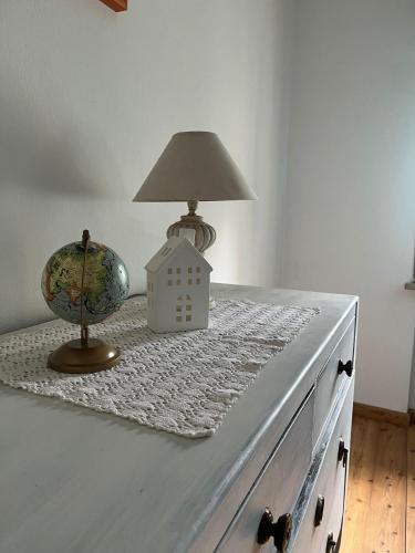 a table with a lamp and a toy house on it at Rovere dalla riva in Arzene