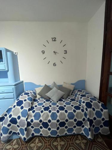 a bedroom with a clock on the wall above a bed at Rovere dalla riva in Arzene