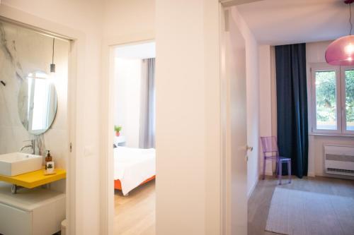 Camera bianca con letto e specchio di Appartamento Elise a Siderno Marina