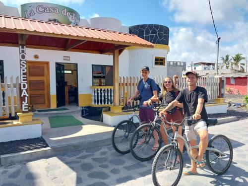 drie personen op de fiets voor een restaurant bij La Casa de Joel in Puerto Villamil