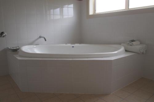 a white bath tub in a bathroom with a window at Alexander Cameron Suites in Penola