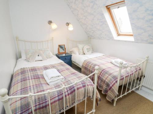 two twin beds in a room with a window at Otters Holt in Llandeilo